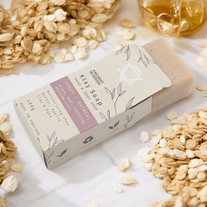 Bar of soap with a label on a surface with oats and honey.